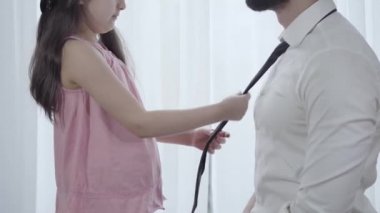 Tanınmayacak halde küçük bir kız sabahları yetişkin adam kıyafetlerini tamir ediyor. Ciddi bir Ortadoğu kızı, babasının kravatını evde bağlıyor. Aile, bakım, birlik, yaşam tarzı.