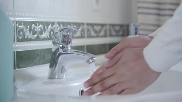 Close-up zijaanzicht van mannelijke handen die elkaar wassen met water. Onherkenbare opgeruimd man doet hygiëne procedure. Gezondheidszorg, antivirale maatregelen, Covid-19. — Stockvideo
