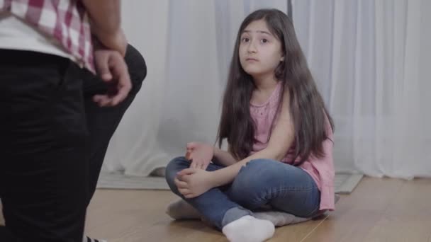 Egy rémült közel-keleti lány arcképe, aki a fejét rejtegeti, miközben felismerhetetlen férfi fenyegeti. Boldogtalan gyermek, akit apa szidott. Családi erőszak, stressz, gyermekkor. — Stock videók