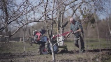 Kıdemli Kafkasyalı adam ilkbaharın başlarında elle verimli Ukrayna toprağı kazıyor. Yaşlı adam, otoban kullanarak patates ekimi için yol açıyor. Tarım, tarım, kırsal yaşam tarzı.