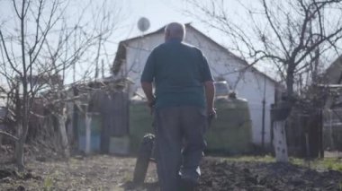 Olgun, beyaz bir adamın el çırpışları baharın başlarında verimli toprakları yaralayan elleri. Yaşlı erkek çiftçi kırsal alanda çalışıyor ve çalı çırpı yapmak için ekipman kullanıyor. Tarım, tarım.