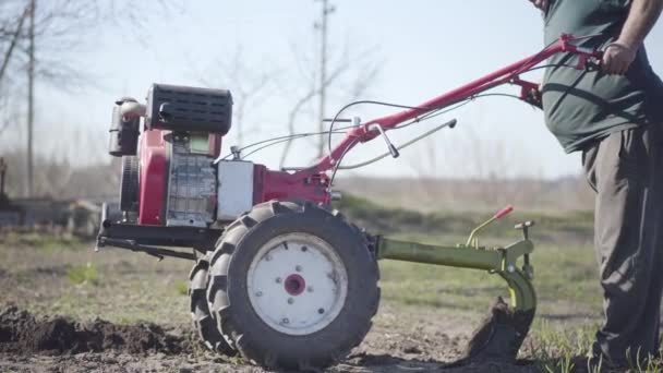 Kamera folgt Furcher in männlichen kaukasischen alten Hasen. Bis zur Unkenntlichkeit gereifter Bauer, der Boden für Gemüseanpflanzungen zerfurcht. Landwirtschaft, Landwirtschaft. — Stockvideo