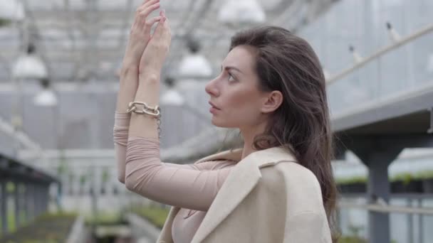 Enigmatic brunette woman in massive bracelet holding hand up and thinking. Thoughtful lady with brown eyes in elegant outfit thinking. Close-up. — Stock Video