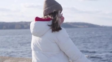 Nehir kıyısında dikilip bakışlarını kaçıran düşünceli genç bir kadın. Kafkasyalı güzel esmer kız hafta sonları dışarıda dinleniyor. Yaşam tarzı, neşe, eğlence, mutluluk, yalnızlık.