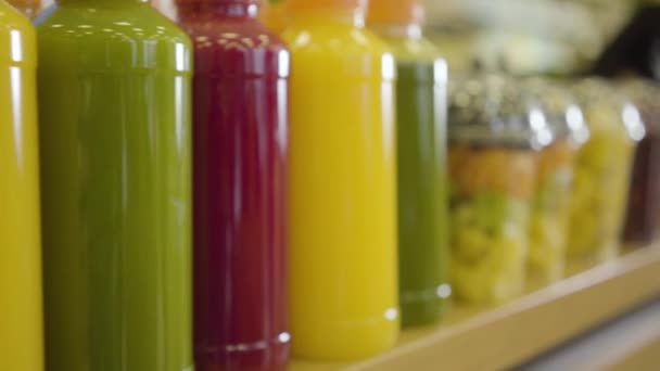 Primer plano fila de zumos frescos y frutas secas de colores en el estante de la tienda. Cámara moviéndose a lo largo de mercancías en el supermercado. Comida saludable, vitaminas, tienda minorista . — Vídeos de Stock