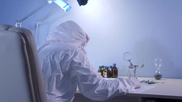 Обратный вид медицинского работника в защитном костюме, лежащем на столе. Уставший доктор, у которого был перерыв во время пандемии Ковида-19. Коронавирус, вирус, инфекция, здравоохранение, образ жизни . — стоковое видео