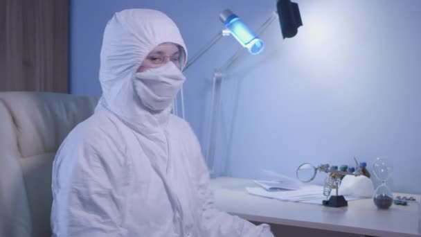 Молодой белый доктор в защитном костюме поворачивается к камере и показывает большой палец вверх. Улыбающаяся женщина выражает хорошие новости о вирусной пандемии. Ковид-19, блокировка, коронавирусная болезнь . — стоковое видео