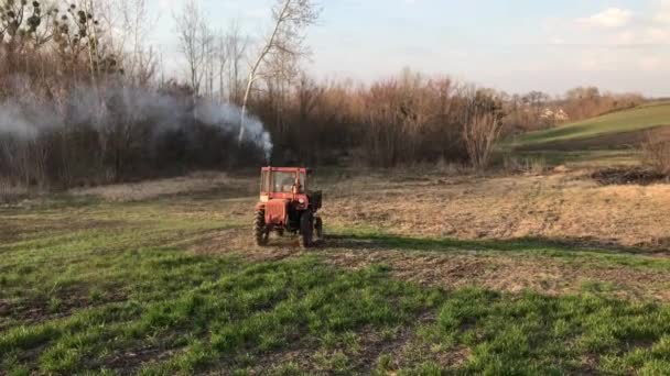 Широкий постріл трактора на весняному полі в сонячний день. Сільське господарство, садівництво, ландшафтний дизайн, сільський спосіб життя, природа . — стокове відео