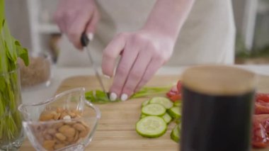 Kadın eli kesme tahtasında marul yaprağı kesiyor. Tanımlanamayan beyaz kadın içeride organik salata hazırlıyor. Vejetaryenlik, restoran işi, sağlıklı beslenme, yaşam tarzı..