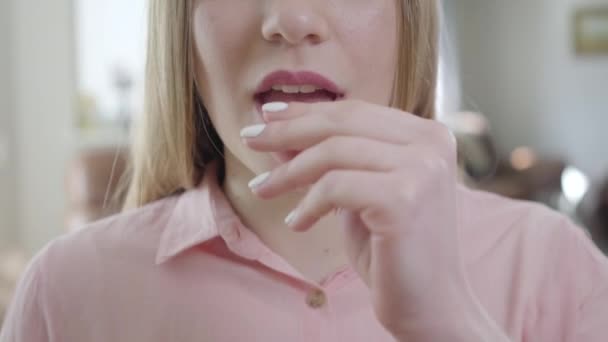 Närbild av oigenkännlig blond vit tjej som stoppar tuggummi i munnen och ler. Nedersta delen av ansiktet på smal söt flicka rengöring tänder efter måltid. Hälsosam livsstil, skönhet, tandvård. — Stockvideo