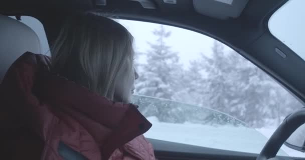Вид сбоку серьезного кавказского водителя, открывающегося и закрывающегося бокового окна. Уверенная женщина наслаждается свежим морозным воздухом в зимнем путешествии. Активный образ жизни, туризм, уверенность. Штаб-квартира кинотеатра 4k ProRes . — стоковое видео