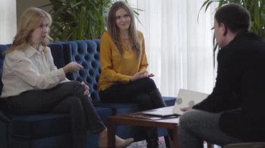 Kendinden emin, kıdemli bir kadın, genç ve neşeli meslektaşı gibi gülümseyen ve destekleyici bir konuşma yapıyor. Kafkasyalı üç iş arkadaşının iş görüşmesi. Proje tartışıyorlar. Takım çalışması, yaşam tarzı, başarı.