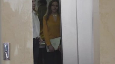 Asansör kapısı açılıyor ve iş adamı bayan meslektaşlarına veda edip gidiyor. İş kadınları asansör kapılarını kapatıyor. Nezaket, işbirliği, yaşam tarzı, iş.