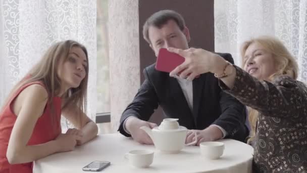 Positivo caucásico hombre y mujeres haciendo selfie en la cámara frontal en la cafetería. Retrato de familia feliz descansando juntos en el restaurante. Momentos memorables de vida, felicidad, estilo de vida . — Vídeos de Stock