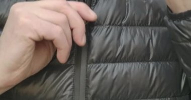 Beyaz erkek eli, siyah ceketini çıkartırken yakın plan. Baharda ya da sonbahar günü açık havada kendini sıcak hisseden kimliği belirsiz yetişkin bir adam. Sinema 4k ProRes Merkezi.