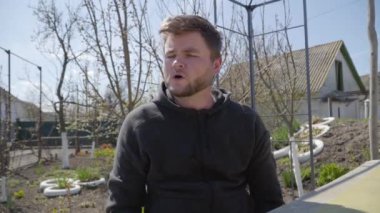 Duygusal beyaz adam kameraya tamamen karşı çıkıyor. Genç sakallı esmer adamın portresi başını sallayarak hayır işareti yapıyor ve internette iş arkadaşlarıyla konuşuyor. Uzaktan kumanda, Covid-19 tecrit.