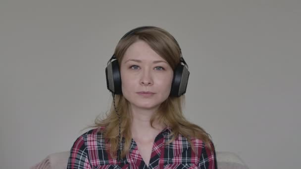 Retrato de una mujer joven agotada con auriculares mirando a la cámara y bostezando. Joven empleado cansado que tiene videoconferencia en línea con colegas en el bloqueo de Covid-19. Comunicación inalámbrica . — Vídeo de stock