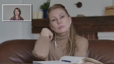 Mutsuz Kafkasyalı kadın sıkıcı iş arkadaşını dinliyor görüntülü sohbet ediyor ve esniyor. İnternette iş arkadaşıyla projeyi tartışan sıkılmış kadının portresi. Planlama, iş, uzaktan kumanda, koronavirüs.