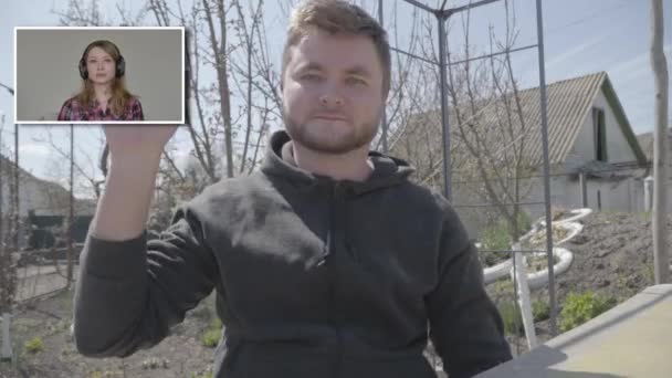 Retrato de un alegre hombre joven saludando a la joven en el chat de vídeo. Caucásico morena chico saludando a la cámara. Comunicación en línea, bloqueo de Covid-19, estilo de vida, autoaislamiento . — Vídeo de stock