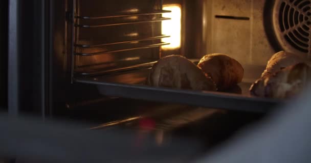 Cook kollar bakade croissanter i ugnen. Oigenkännlig man eller kvinna tar av ugnen bricka med läcker tillagad dessert. Kulinariska rätter, mat, bakning. Bio 4k ProRes HQ. — Stockvideo