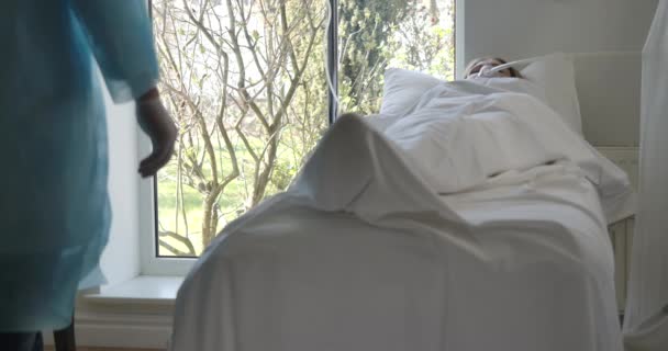 Médico irreconocible llegando a la mujer caucásica enferma acostada en la cama del hospital. Médico varón revisando paciente en el centro médico. Ventilación mecánica de los pulmones, atención médica. Sede del cine 4k ProRes . — Vídeos de Stock