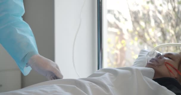 Examen médico de una mujer caucásica enferma acostada en una cama de hospital con una máquina de ventilación. Médico revisando el estado de los pacientes. Concepto de atención de salud, enfermedad respiratoria Covid-19. Sede del cine 4k ProRes — Vídeos de Stock