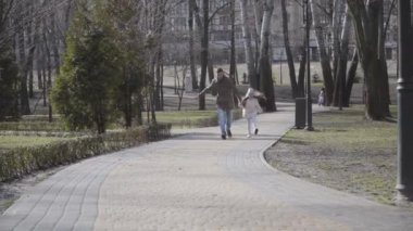 Neşeli Kafkas baba ve kızı parktaki ara sokakta zıplayıp koşuyorlar ve gidiyorlar. Mutlu gülen adam ve kız güneşli bir sonbahar gününde dışarıda eğleniyorlar. Eğlence, eğlence, yaşam tarzı, eğlence..