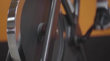 Spor ayakkabılı, spor bisikletli bir erkek. Beden eğitiminde tanınmayan bir adamın yakın çekimi. Spor malzemeleri, sağlıklı yaşam tarzı, egzersiz..