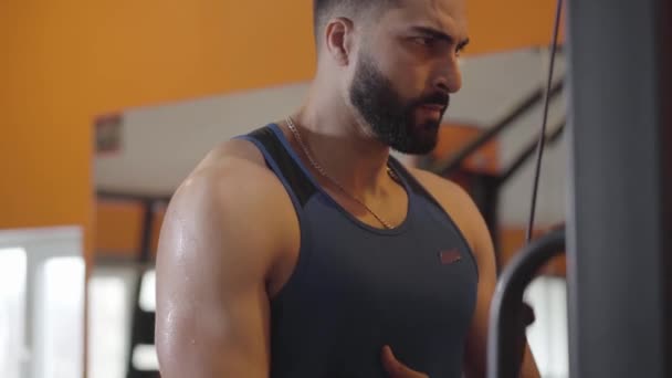 Primer plano de deportista transpirante grave entrenamiento de la mano muscular construido en el gimnasio. Retrato del joven y confiado hombre de Oriente Medio tirando de la banda de resistencia. Resistencia, deporte, tensión, estilo de vida . — Vídeos de Stock