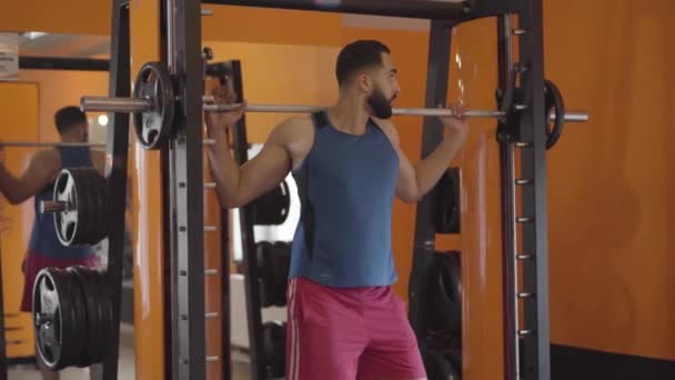 Ung sportig Mellanöstern man lyfta vikter i gymmet. Porträtt av stilig idrottsman utbildning i idrottsförening. Hälsa, livsstil, fitness, styrka, muskeluppbyggnad. — Stockvideo