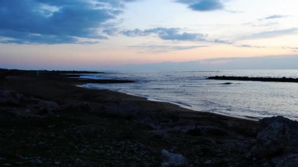 Amplio tiro de noche hermosa en el complejo de Chipre. Puesta de sol en el tranquilo mar Mediterráneo con olas rodando en la playa. Paisaje, naturaleza, tranquilidad, belleza . — Vídeos de Stock