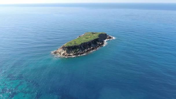 無限の地中海の小さな緑の島。白いカモメが太陽の光で輝く青い深い水の上に島を飛び回っています。キプロスの楽園で晴れた日。自然、海、空の景色の女王. — ストック動画