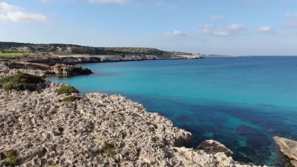 Luchtfoto van kristalheldere blauwe lagune met rotsachtige kust rond. Drone uitzicht op transparant rustig water van de Middellandse Zee op zonnige zomerdag. Natuur, schoonheid, resort, toerisme. — Stockvideo