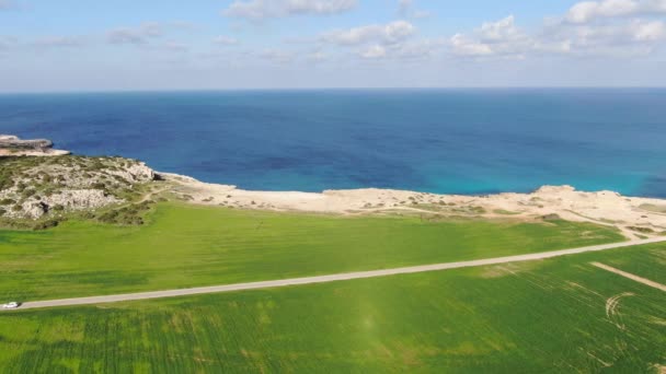 Słoneczny letni krajobraz na Cyprze. Morze Śródziemne i zielona dolina w promieniach słońca. Widok z lotu ptaka, szerokie ujęcie wspaniałej linii brzegowej w świetle słonecznym. Natura, krajobraz morski, turystyka, kurort. — Wideo stockowe