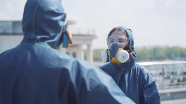 Homme romantique en costume chimique donnant bouquet de roses à jeune belle femme en respirateur. Aimer couple caucasien sortir ensemble en plein air sur Covid-19 verrouillage. Amour, romance, pollution de l'air, danger global . — Video