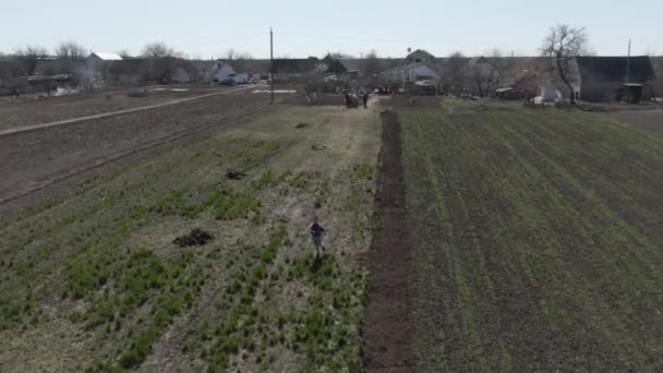 Pequeño niño caucásico alegre corriendo detrás de un dron, vista aérea. Vista superior del alegre niño feliz divirtiéndose en el campo en el soleado día de primavera. Ocio, infancia, felicidad, estilo de vida . — Vídeo de stock