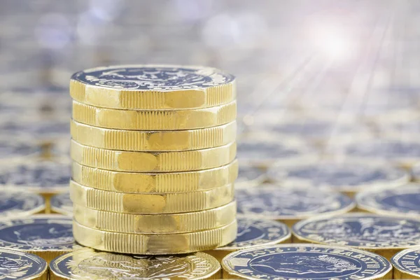 Stack of golden coins with bright sunlight light effects.