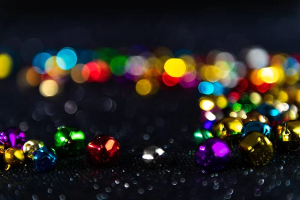 Coloridas campanas de Navidad. Fondo bokeh borroso negro . — Foto de Stock