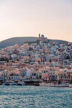 Syros, Yunanistan - 26 Haziran 2019: Yaz mevsiminde şehrin liman kenar sokaklarından ve binalardan günlük