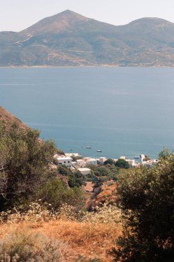 Yunanistan 'ın Milos kentindeki deniz kenarı ve adalara güneşli havalarda bak