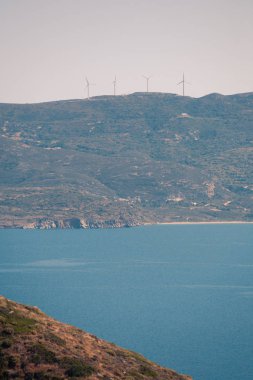 Yunanistan 'ın Milos kentindeki deniz kenarı ve adalara güneşli havalarda bak