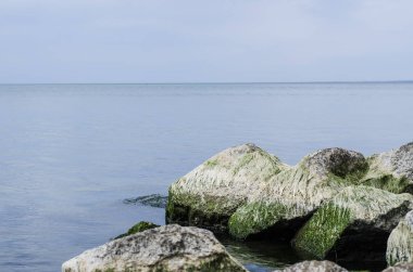 Taşlık bir kıyı ile denizde akşam günbatımı