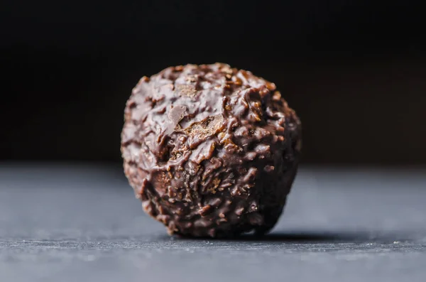 Schokolade runde Bonbons auf einem schwarzen Tisch — Stockfoto