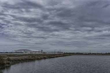 fabrikada alan bulutlu gökyüzü ve göl