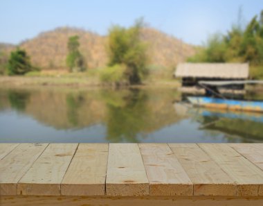 wood table top on blur background of river and mountain view