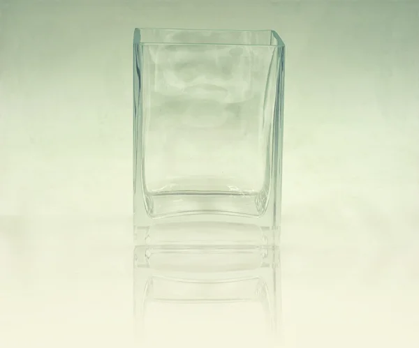 Tigela de óculos transparente no filtro gradiente azul e espelho — Fotografia de Stock