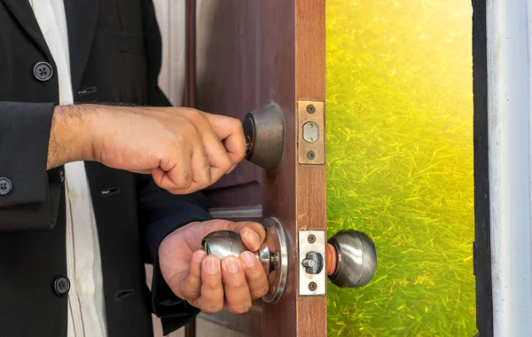 Businessman open the door by key to abstract field on sun light — Stock Photo, Image