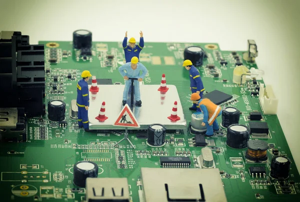 Mini munkavállalók csoportja van megpróbál-hoz kijavít egy alaplap chip — Stock Fotó