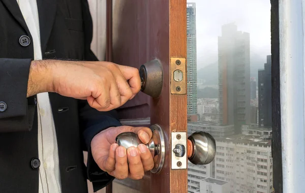 Hombre de negocios abrir la puerta por la llave de la ciudad en lluvia — Foto de Stock