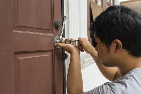 Cerrajero tratar de abrir la vieja puerta de madera por sus herramientas —  Fotos de Stock